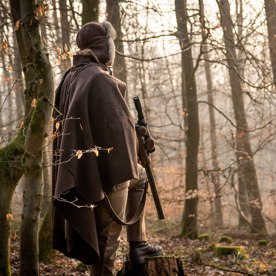 Decke Wetterfleck als Poncho Decke Wetterfleck als Ponchon getragen von Jäger im Wald