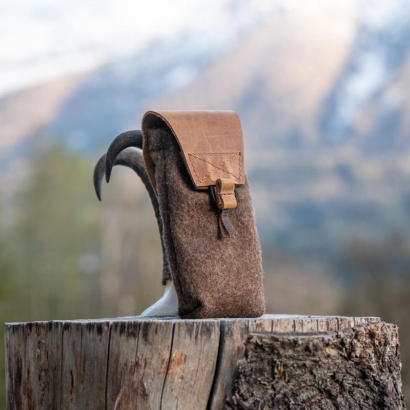 Loden-Täschchen vor Alpen-Hintergrund Täschchen an Gamsgehörn gelehnt