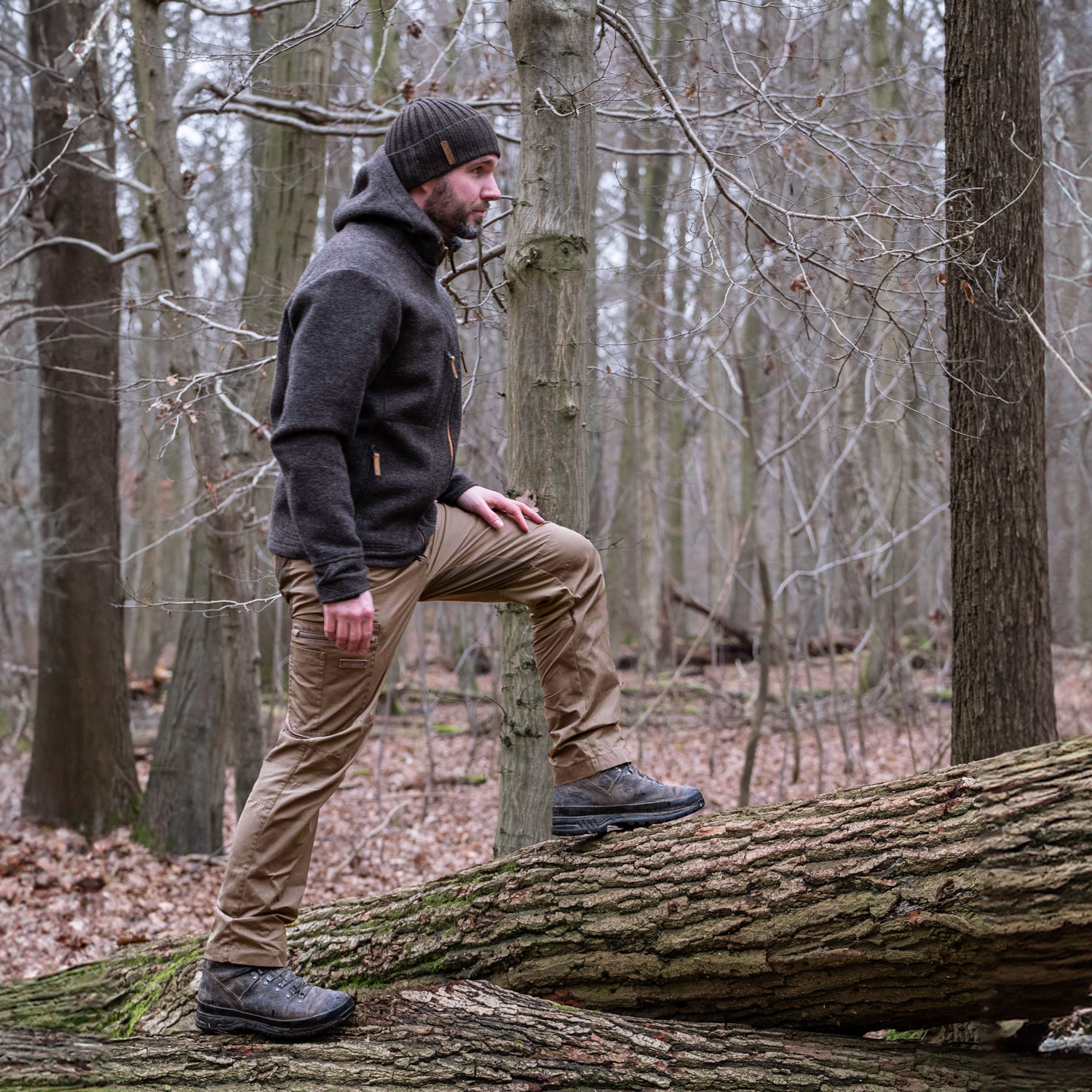 Wanderer im Herbstwald Wanderer steigt auf liegenden Baum